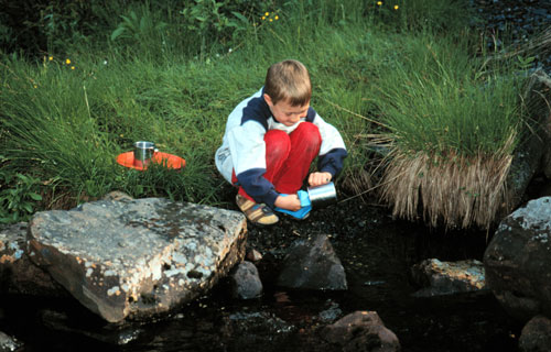 Arian beim Abwasch am Bach